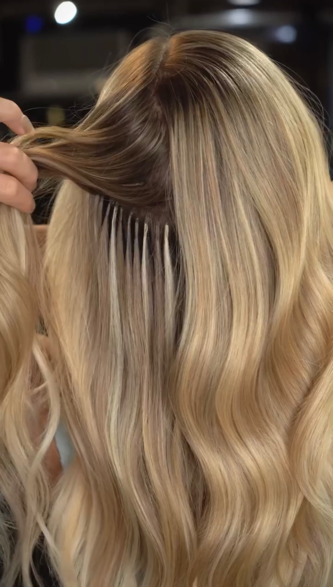 Keratin tip extensions being placed for natural volume and length